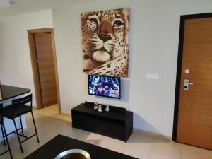 Lovely 3 Bedroom Apartment on Golf Resort في ألاما دي مرسية: غرفة معيشة فيها لوحة فهد