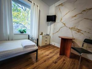 een slaapkamer met een bed, een bureau en een raam bij Ośrodek Sportowo-Wypoczynkowy in Choszczno