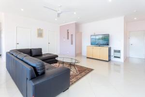 Tuggeranong Short Stay #06C - Sleeps 6 في كانبرا: غرفة معيشة مع أريكة وطاولة