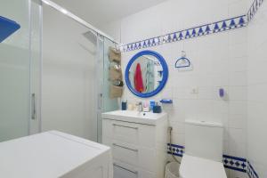 a bathroom with a toilet and a sink and a mirror at Patio Andaluz a 100 metros de la playa in Fuengirola +4 photos
