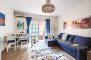a living room with a blue couch and a table at Patio Andaluz a 100 metros de la playa in Fuengirola