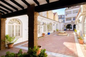 an empty courtyard of a building with potted plants at Patio Andaluz a 100 metros de la playa in Fuengirola