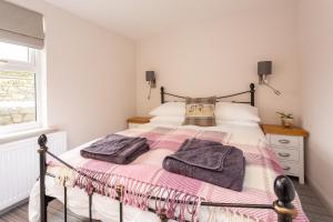 a bedroom with a bed with towels on it at Howgills House Hotel in Sedbergh