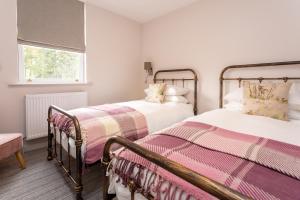 two twin beds in a room with a window at Howgills House Hotel in Sedbergh