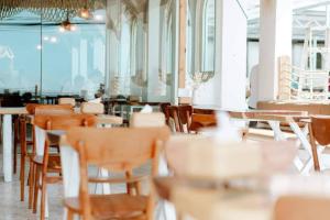 una fila de mesas y sillas en un restaurante en Tawaen Caza Sky Camping, en Koh Larn