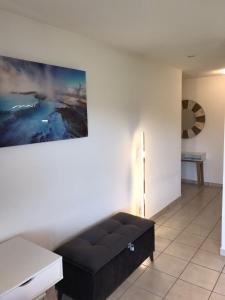 a black couch in a room with a painting on the wall at ZenBNB - ISIS - Piscine - Balcon - 4 Pers in Nangy +3 photos