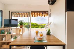 een eetkamer met een tafel en een groot raam bij Rêves Ensablés * Clim * Proche Mer * Terrasse * Port Camargue in Le Grau-du-Roi