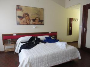 a bedroom with a bed with a painting on the wall at Hotel San Michele in Aprilia