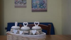 a basket with three white vases on a table at Bridge's House - a 50 mt dalla spiaggia e da tutti i servizi! in Pescara