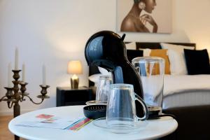 a table with glasses and a black iron on it at Schiller Rooms in Sibiu +73 photos