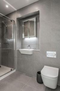 a bathroom with a toilet and a sink and a shower at Beachside: New two bedroom apartment with parking in Kent