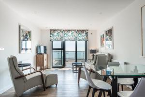 a living room with a table and chairs and a window at Beachside: New two bedroom apartment with parking in Kent