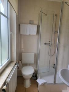 uma casa de banho com um WC, um chuveiro e um lavatório. em Villa Wally em Westerland