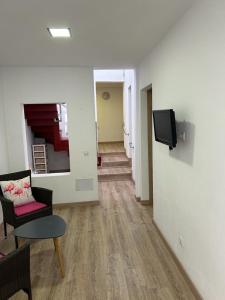 a living room with a couch and a tv on a wall at Casita bonita in Las Palmas de Gran Canaria