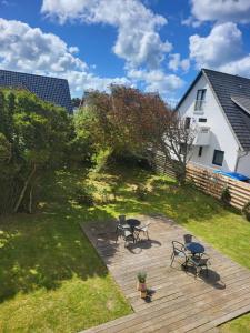 a deck with chairs and tables in a yard at Villa Wally in Westerland (Sylt)