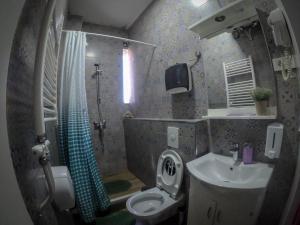 a bathroom with a sink and a toilet and a shower at Urban Cozy Retreat in Pristina +21 photos