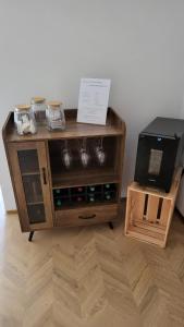a wooden cabinet with cups and a television on it at Pension Zur Neuenburg in Freyburg