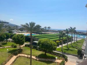 Elle offre une vue sur un parc planté de palmiers et l'océan. dans l'établissement Stunning Sea Front Chalet In Tripoli, à Trâblous