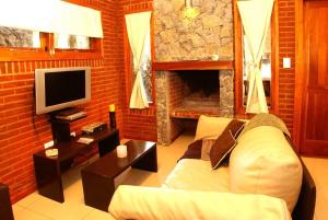 sala de estar con sofá y TV en Escondida en el Bosque en Mar de las Pampas