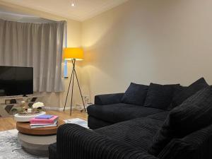 - un salon avec un canapé et une télévision dans l'établissement Forest Edge, à Woodford Green