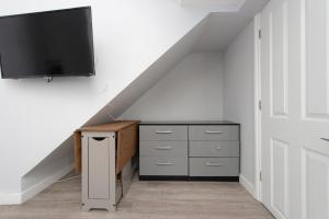 a room with a dresser and a flat screen tv at Fab garden flat central Camden in London