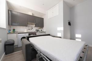 a hospital bed in a room with a kitchen at Fab garden flat central Camden in London