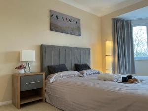 a bedroom with a large bed and a window at Forest Edge in Woodford Green