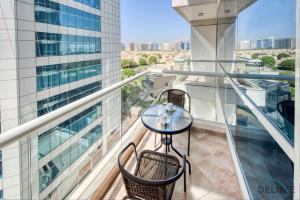 balkon ze stołem i krzesłami w budynku w obiekcie Serene 1BR at Park Terrace Silicon Oasis by Deluxe Holiday Homes w Dubaju