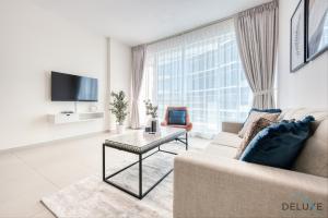 a living room with a couch and a tv at Serene 1BR at Park Terrace Silicon Oasis by Deluxe Holiday Homes in Dubai