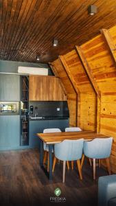 cocina y comedor con mesa de madera y sillas en Freskia Resort en Ferizaj