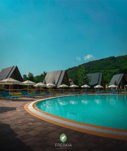 a large swimming pool with umbrellas and a resort at Freskia Resort in Ferizaj