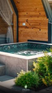 bañera de hidromasaje en una habitación con pared de madera en Freskia Resort en Ferizaj