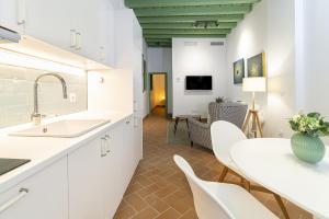 - une cuisine avec des placards blancs, une table et des chaises dans l'établissement Veoapartment Cantabria, à Séville