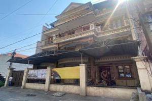 a building with umbrellas in front of it at OYO 93202 Pentagon Homestay Syariah in Surabaya