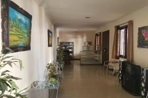 a hallway with tables and chairs in a building at OYO 93202 Pentagon Homestay Syariah in Surabaya