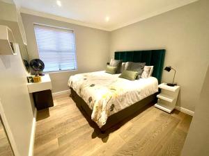 a bedroom with a bed with a green headboard and a window at Atlantic Cove in Cape Town