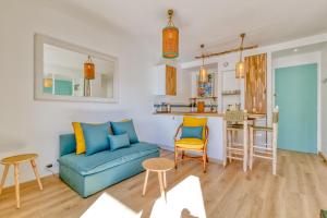 uma sala de estar com um sofá azul e uma cozinha em Vue sur mer La Baule Riviera em La Baule