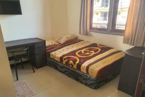 ein kleines Schlafzimmer mit einem Bett und einem Schreibtisch in der Unterkunft OYO 93202 Pentagon Homestay Syariah in Surabaya