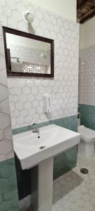 een badkamer met een wastafel, een spiegel en een toilet bij xplorest in Mysore