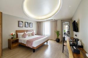 a hotel room with a bed and a tv at My Downtown - The Red Pier in Udaipur