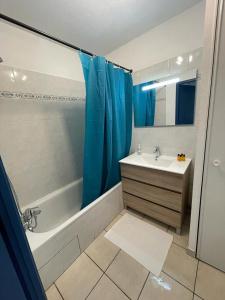 ein Bad mit einer Badewanne, einem Waschbecken und einer Dusche in der Unterkunft ZenBNB / Léman / Garage /Balcon/ Piscine in Annemasse