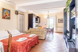 a room with a bed and a couch and a table at Dolmen House in Montalbano Elicona