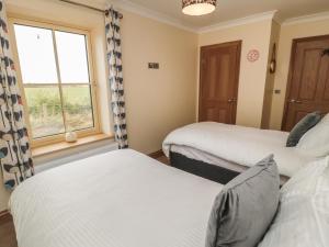 twee bedden in een kamer met een raam bij Whinny Cottage in Alnwick +29 foto's