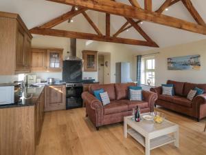 a living room with two couches and a kitchen at Smithy Cottage in Alnwick