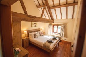 a bedroom with a bed and a wooden floor at The Threshing Barn in Woodhall Spa