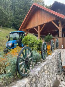 a tractor parked in front of a building with flowers at Boutique Tourist Farm Hrovat in Frankolovo