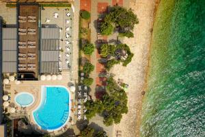 an aerial view of a beach with a swimming pool and the ocean at Hotel Pinija in Petrcane