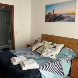 1 dormitorio con 1 cama con toallas en Vivienda de uso turistico, en Ribadavia