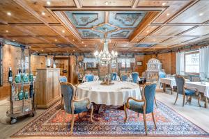 uma sala de jantar com uma mesa e cadeiras e um lustre em Trofana Royal 5-Sterne Superior Resort em Ischgl