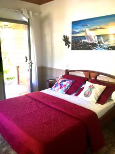 a bedroom with a large bed with a red blanket at Saint Leu - Chambre 3 épis avec PDJ piscine en pleine nature vue mer - Bardzour in Saint-Leu